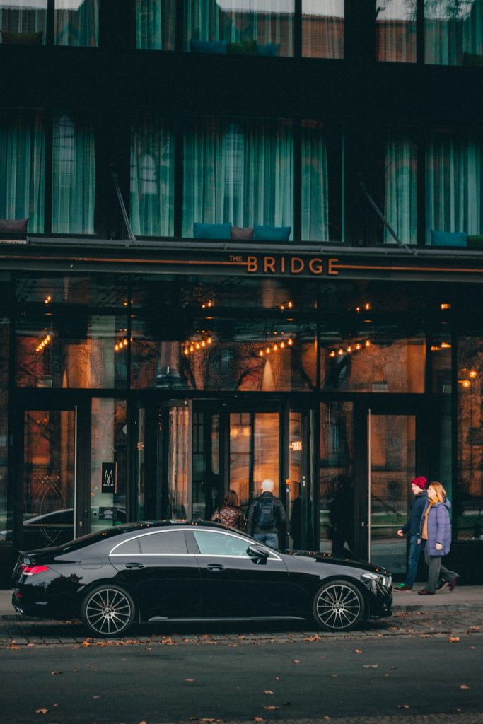 a-black-car-parked-in-front-of-a-building-7nodpnrbgyi